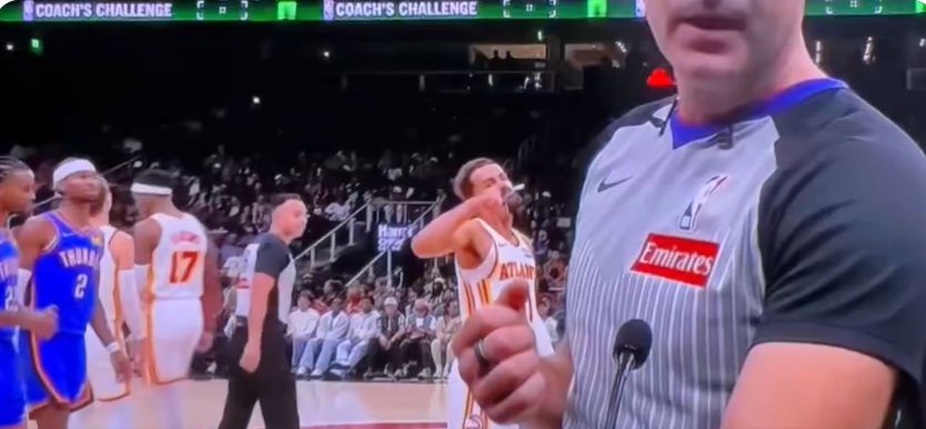 Không sợ bị phạt à? Trae Young làm động tác chỉ ngón tay cái về phía trọng tài để bày tỏ sự không hài lòng